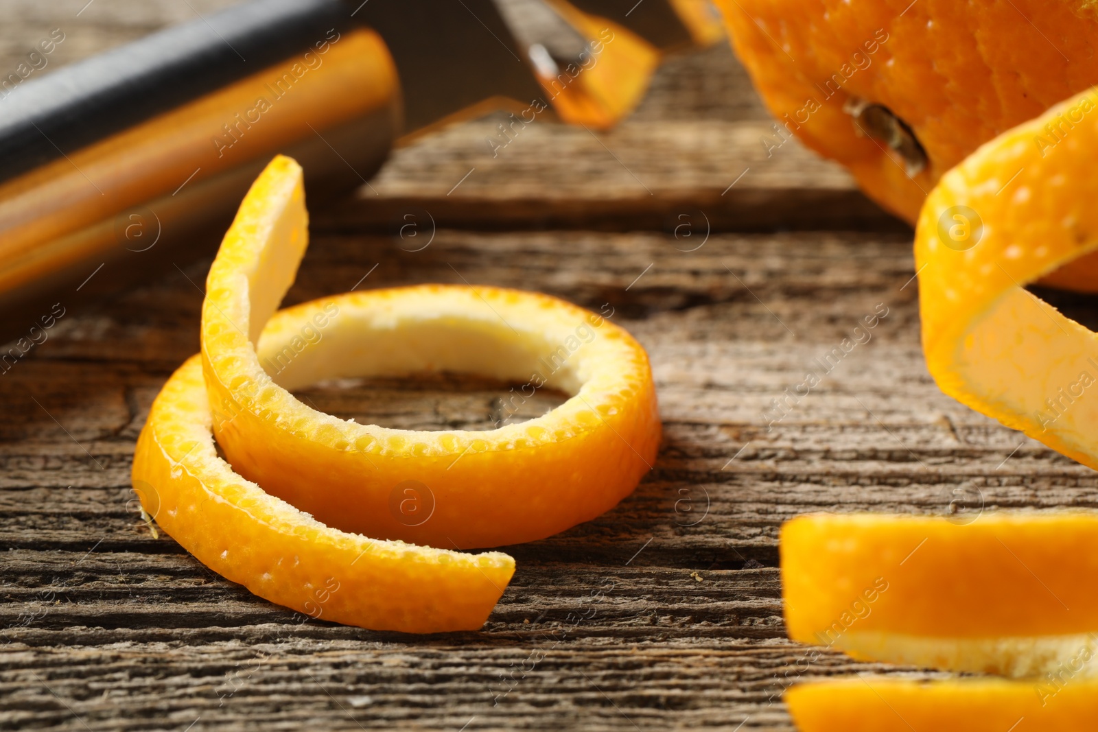 Photo of Fresh orange peels on wooden table, closeup