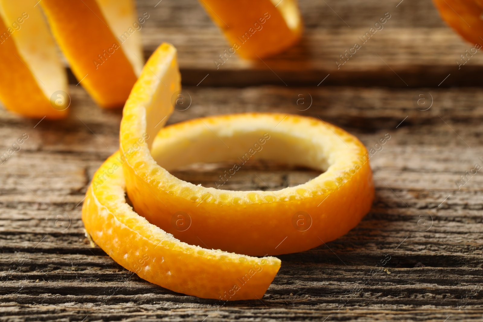 Photo of Fresh orange peels on wooden table, closeup