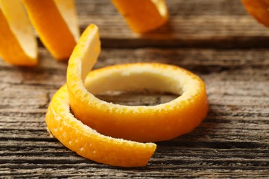 Photo of Fresh orange peels on wooden table, closeup