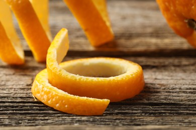 Photo of Fresh orange peels on wooden table, closeup