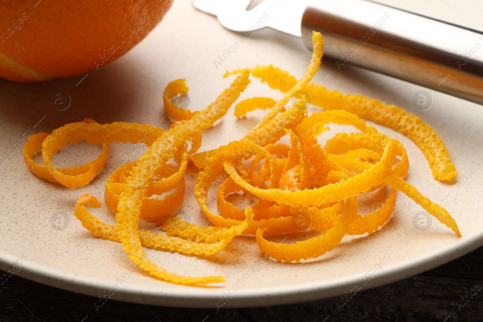 Photo of Fresh orange zest and fruit on plate, closeup