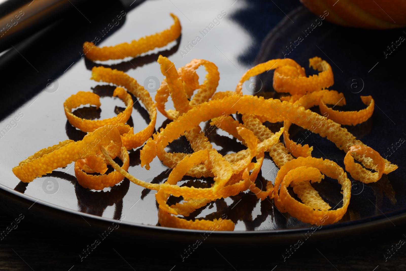 Photo of Pile of fresh orange zest on plate, closeup