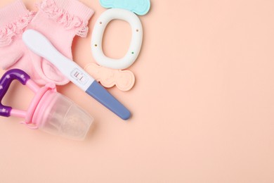 Photo of Pregnancy test, baby socks and toys on pink background, flat lay. Space for text