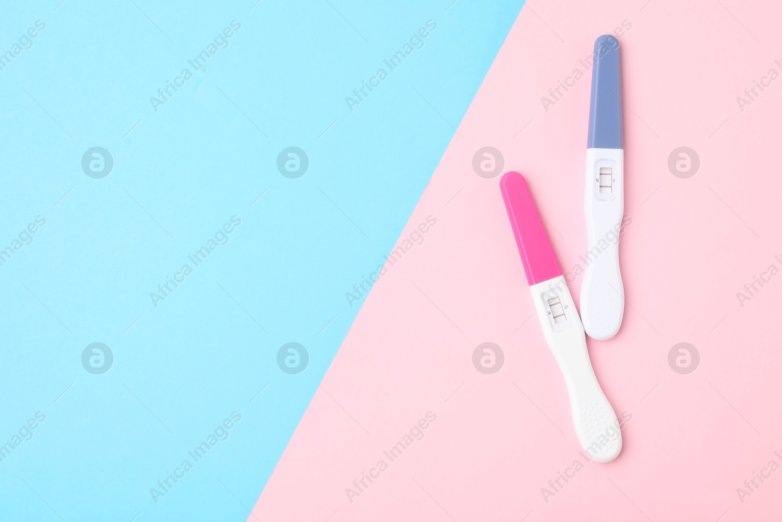 Photo of Two pregnancy tests on color background, top view. Space for text