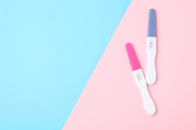 Photo of Two pregnancy tests on color background, top view. Space for text