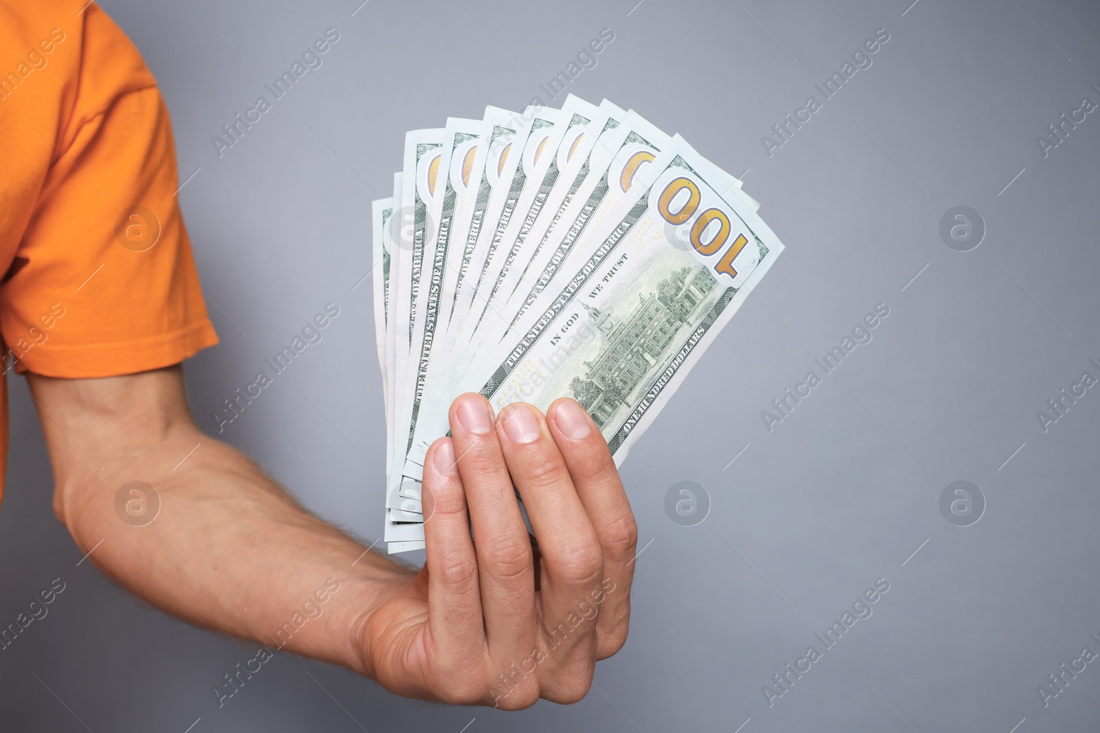 Photo of Man with dollar banknotes on grey background, closeup