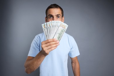 Photo of Man with dollar banknotes on grey background