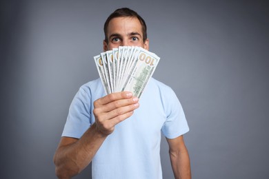 Photo of Man with dollar banknotes on grey background