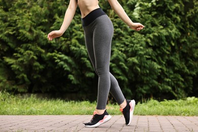 Woman wearing stylish sports leggings outdoors, closeup