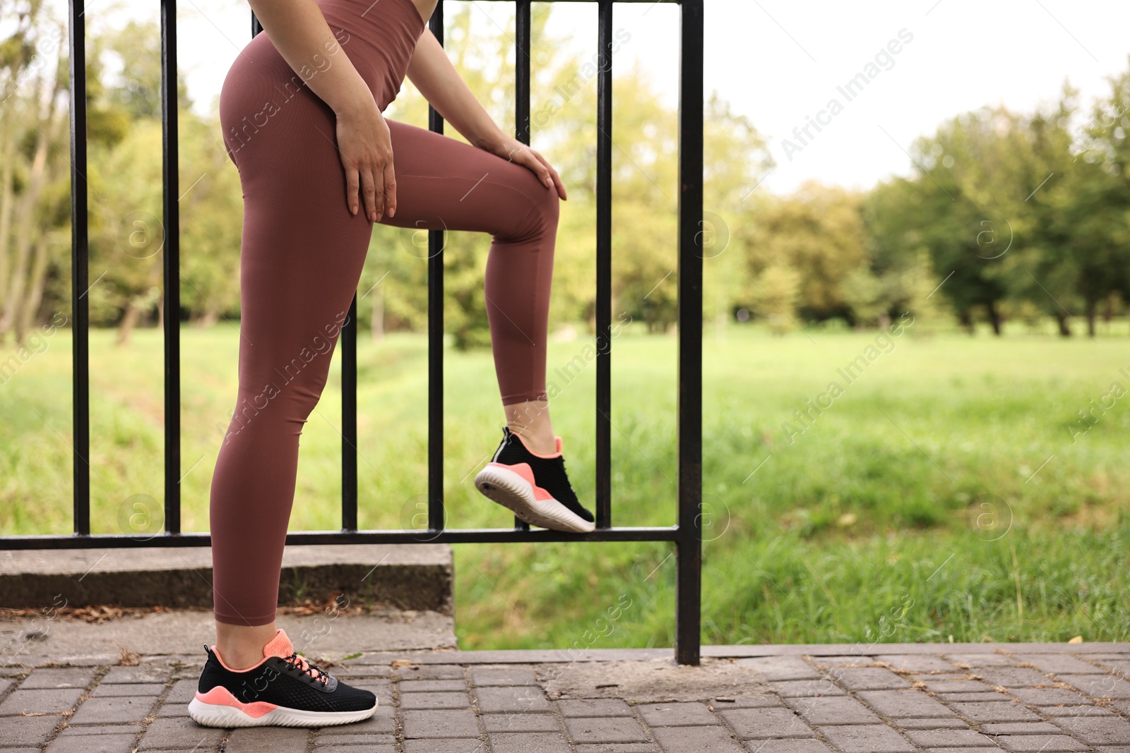 Photo of Woman wearing sports leggings outdoors, closeup. Space for text