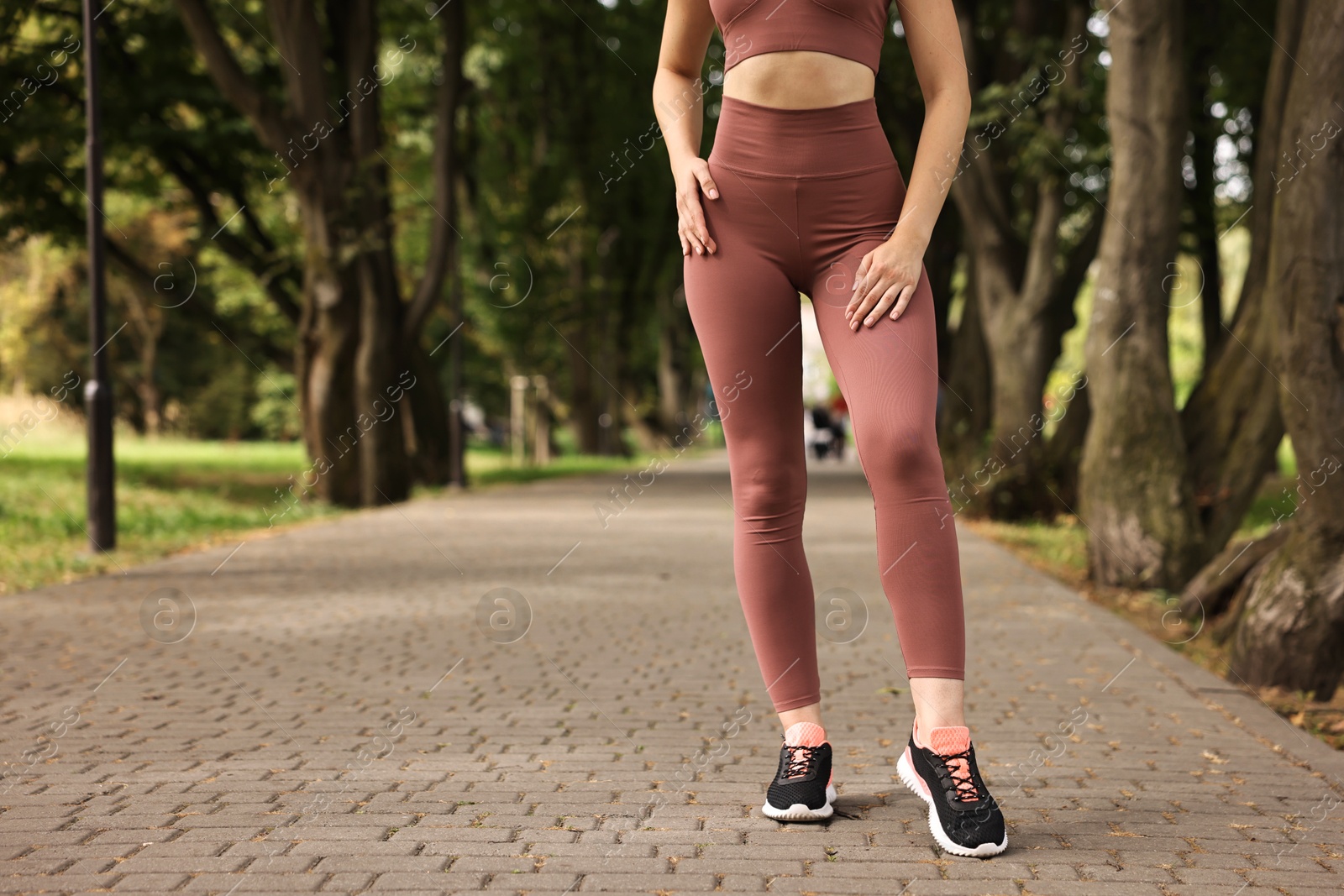 Photo of Woman wearing sports leggings outdoors, closeup. Space for text