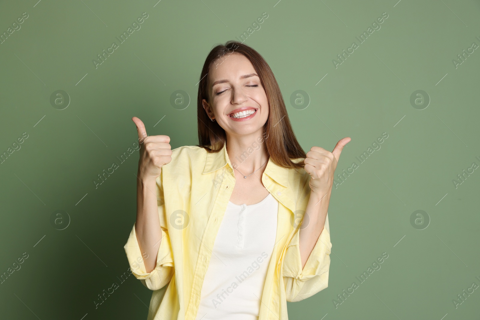 Photo of Happy winner showing thumbs up on green background