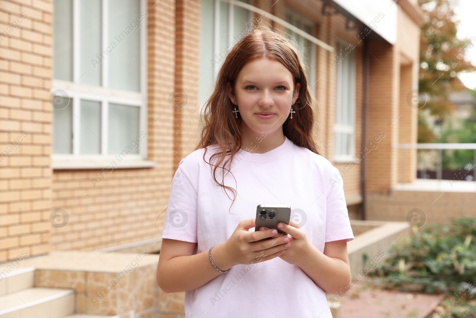 Photo of Portrait of beautiful teenage girl with smartphone outdoors