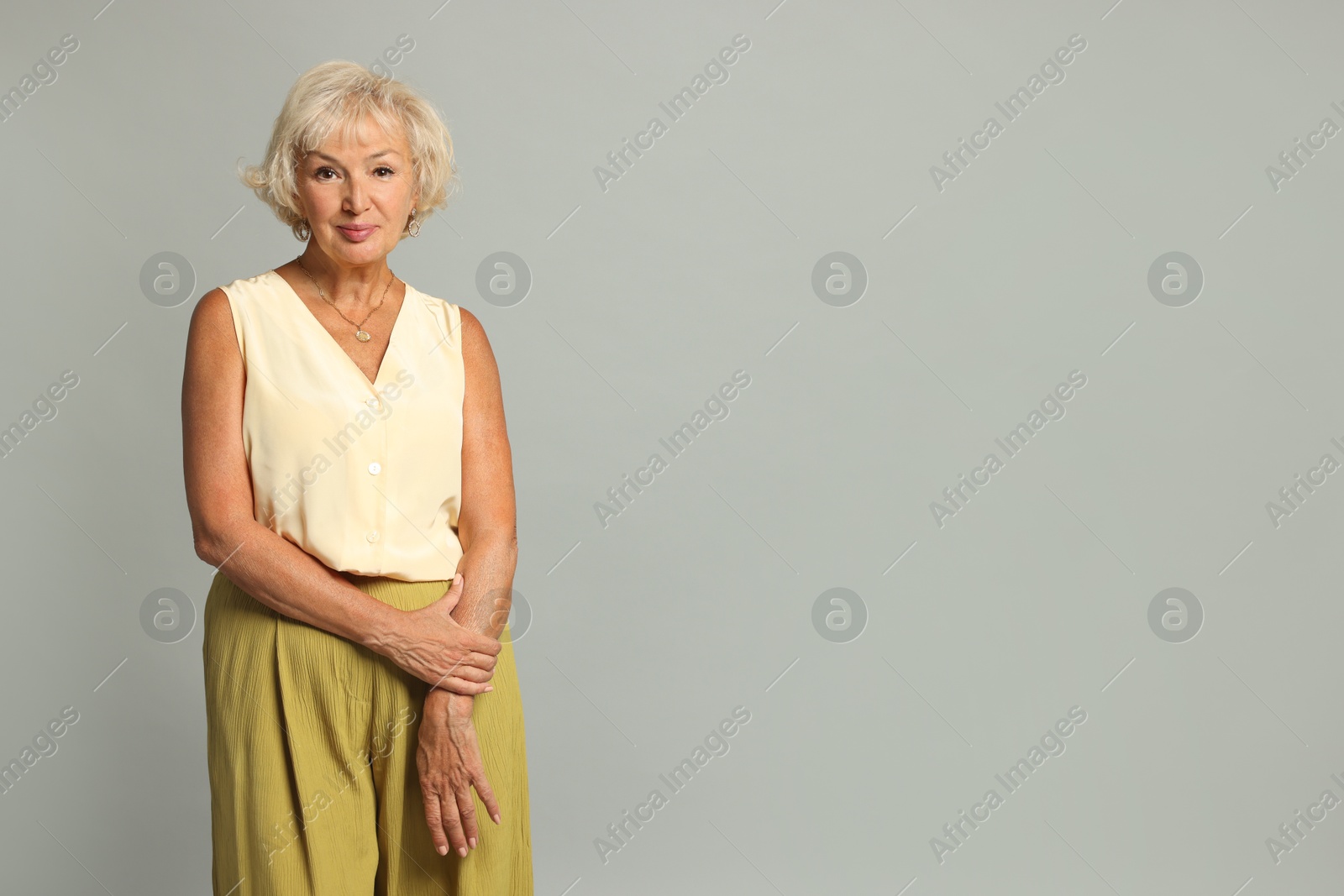 Photo of Portrait of beautiful senior woman on light grey background, space for text