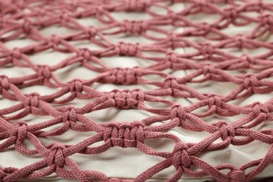 Photo of Handmade macrame shopping bag as background, closeup