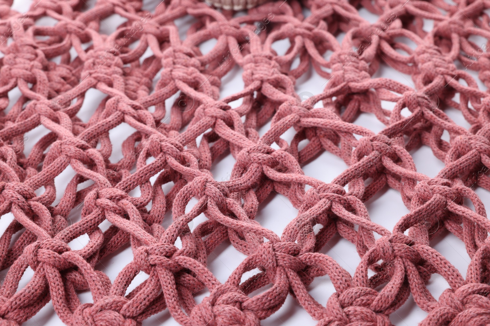 Photo of Handmade macrame shopping bag on white background, closeup