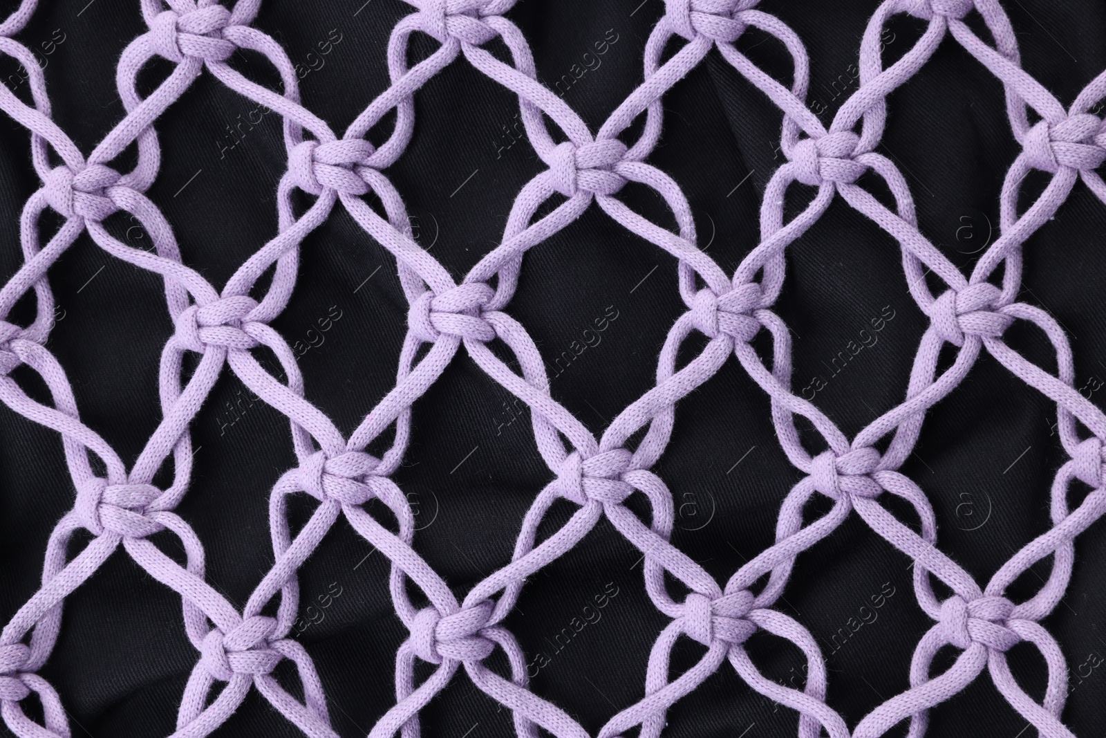 Photo of Handmade macrame shopping bag as background, closeup