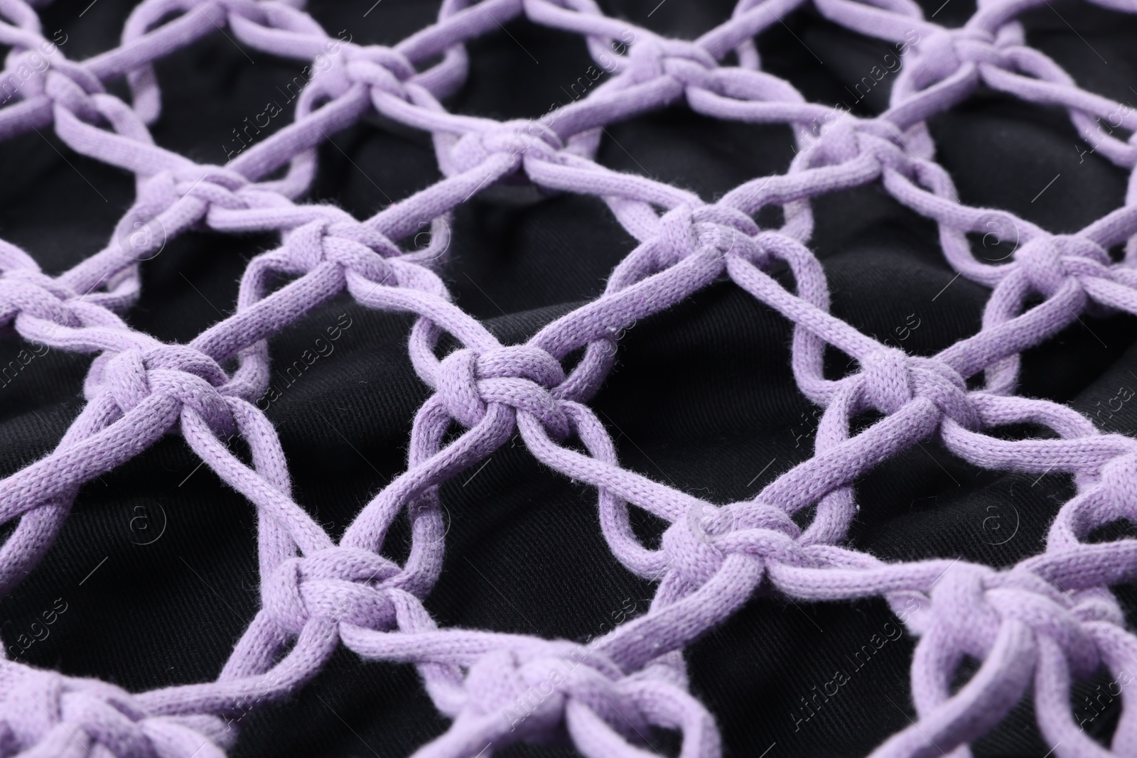 Photo of Handmade macrame shopping bag as background, closeup