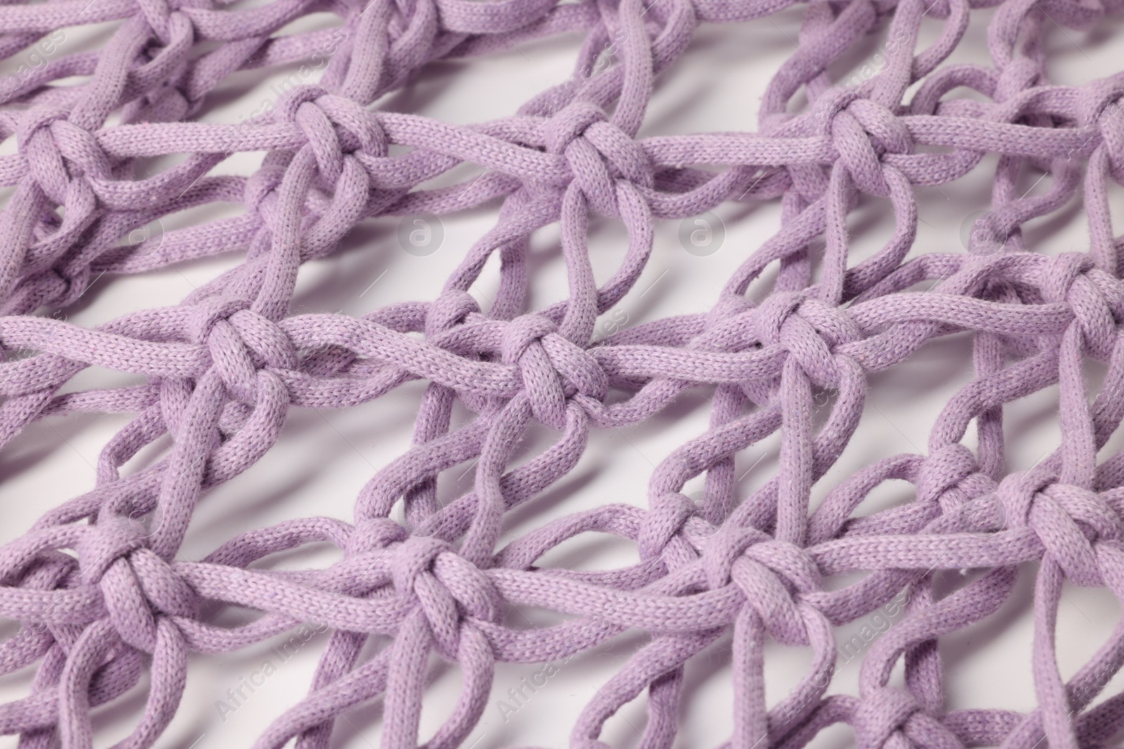 Photo of Handmade macrame shopping bag on white background, closeup