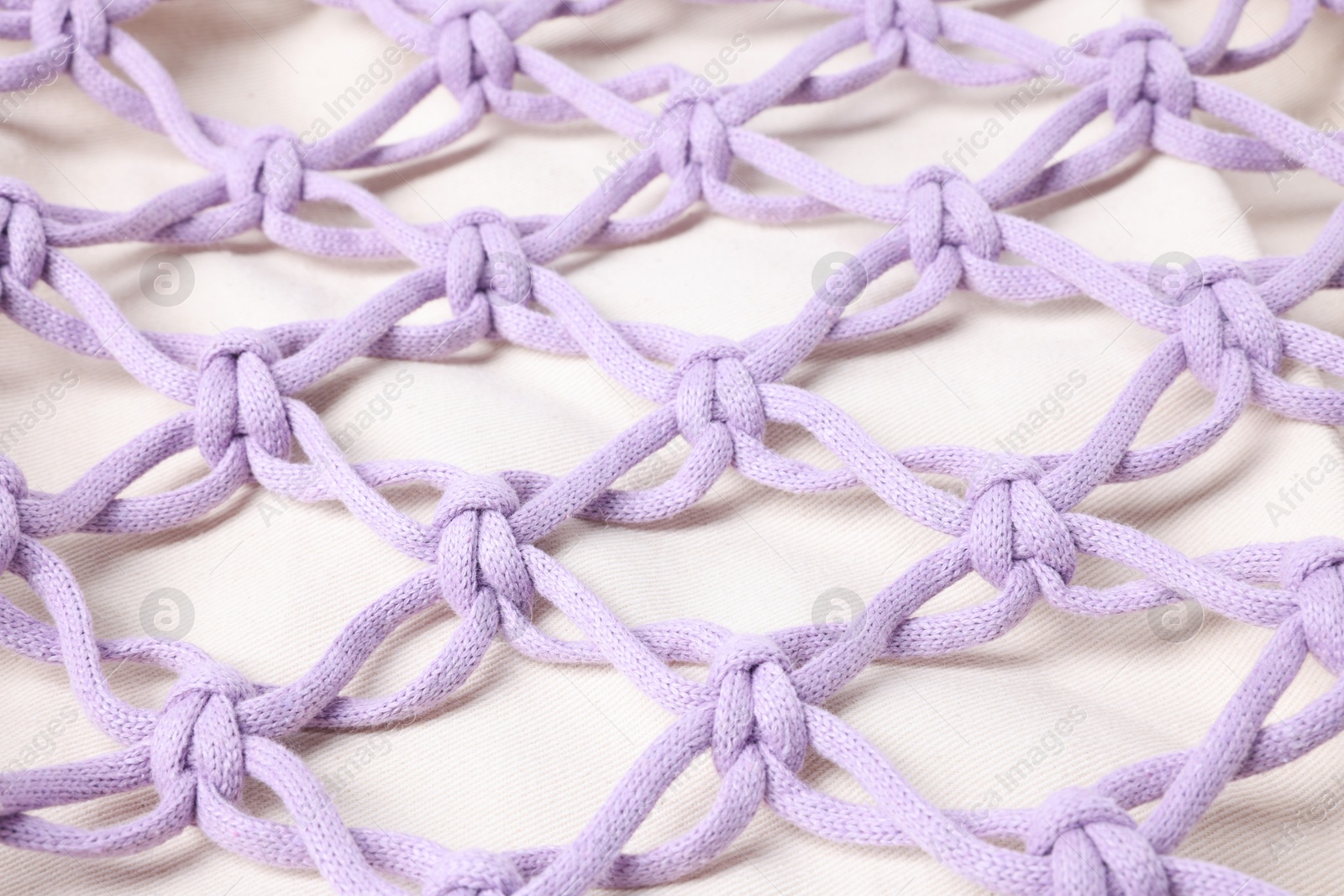 Photo of Handmade macrame shopping bag as background, closeup