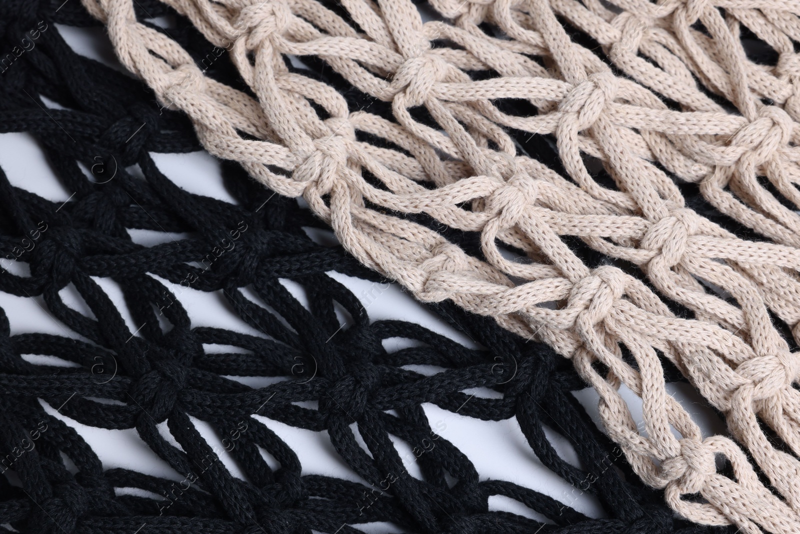 Photo of Two macrame shopping bags on white background, closeup