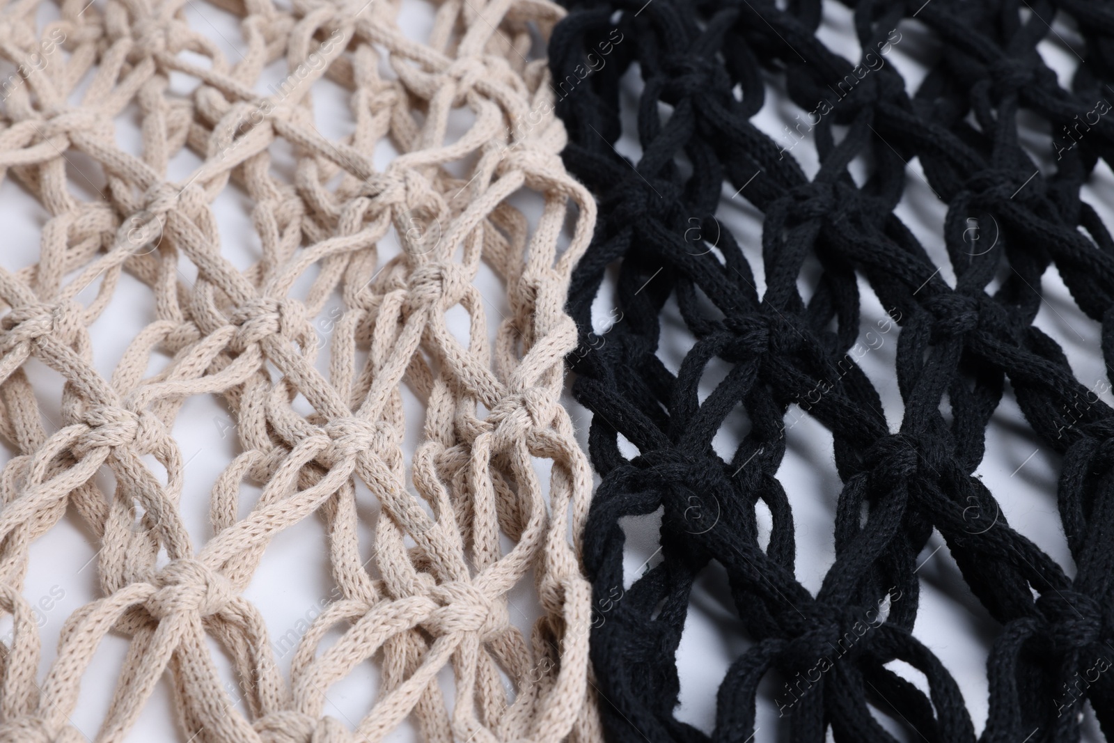 Photo of Two macrame shopping bags on white background, closeup