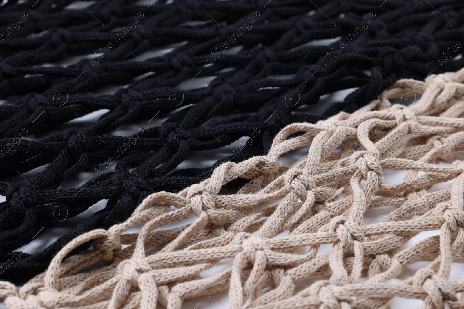 Photo of Two macrame shopping bags on white background, closeup