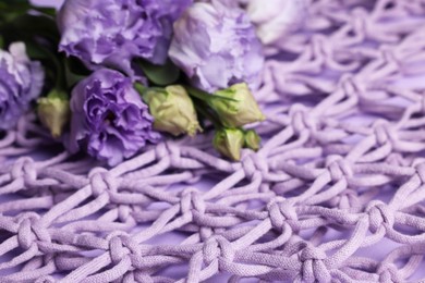 Photo of Flowers on handmade macrame shopping bag, closeup