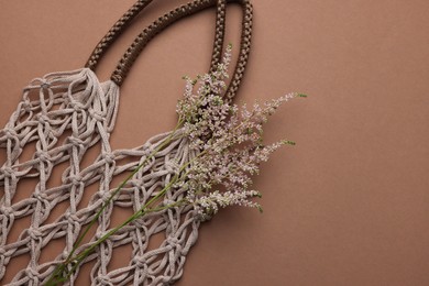 Photo of Handmade macrame shopping bag with spikes on brown background, top view. Space for text