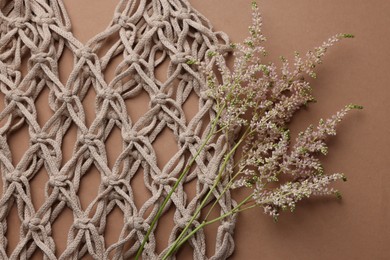 Photo of Handmade macrame shopping bag with spikes on brown background, top view