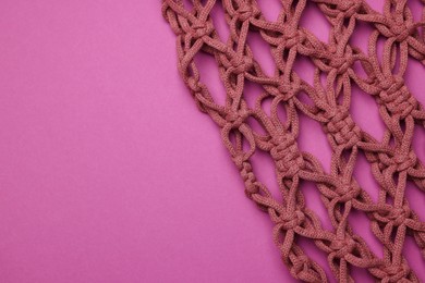 Photo of Handmade macrame shopping bag on crimson background, top view. Space for text