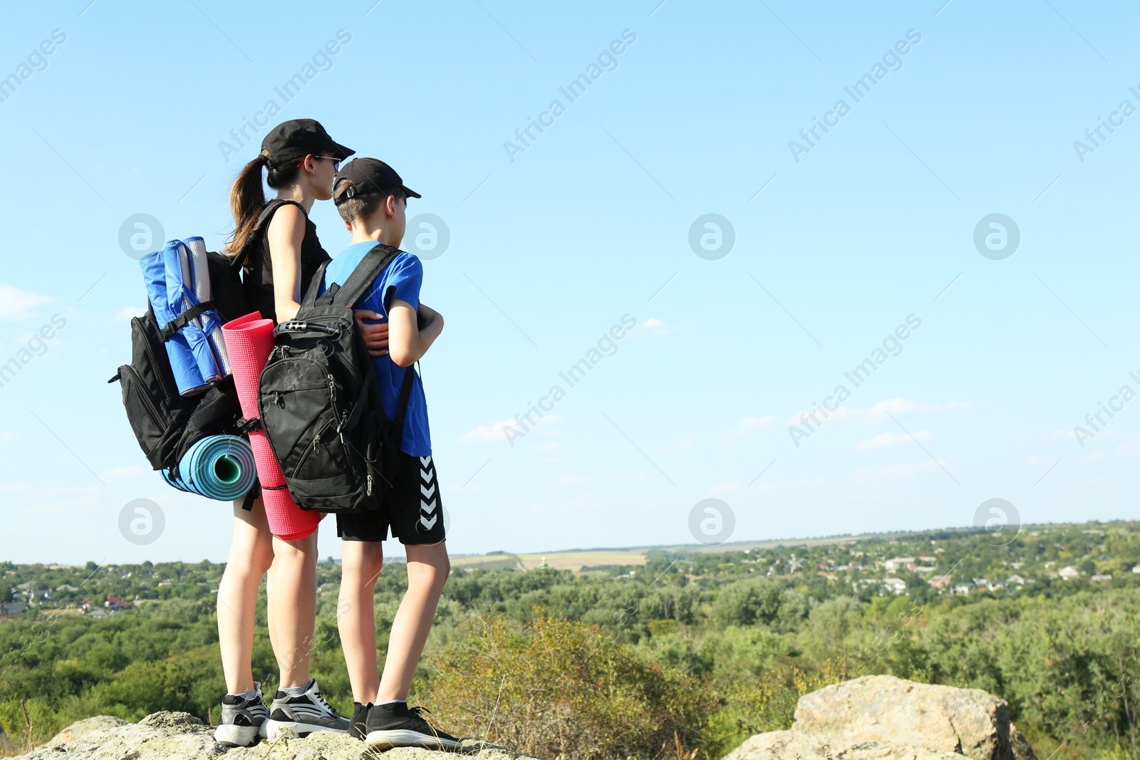 Photo of Mother and son enjoying picturesque landscape, back view. Space for text