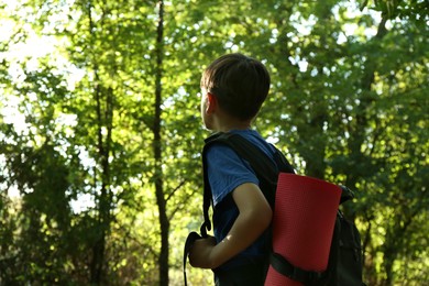 Little boy with backpack travelling outdoors, low angle view. Space for text