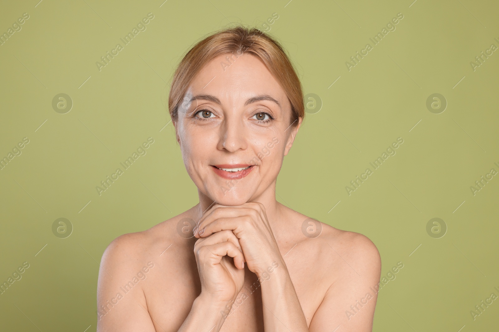 Photo of Portrait of smiling woman with healthy skin on green background