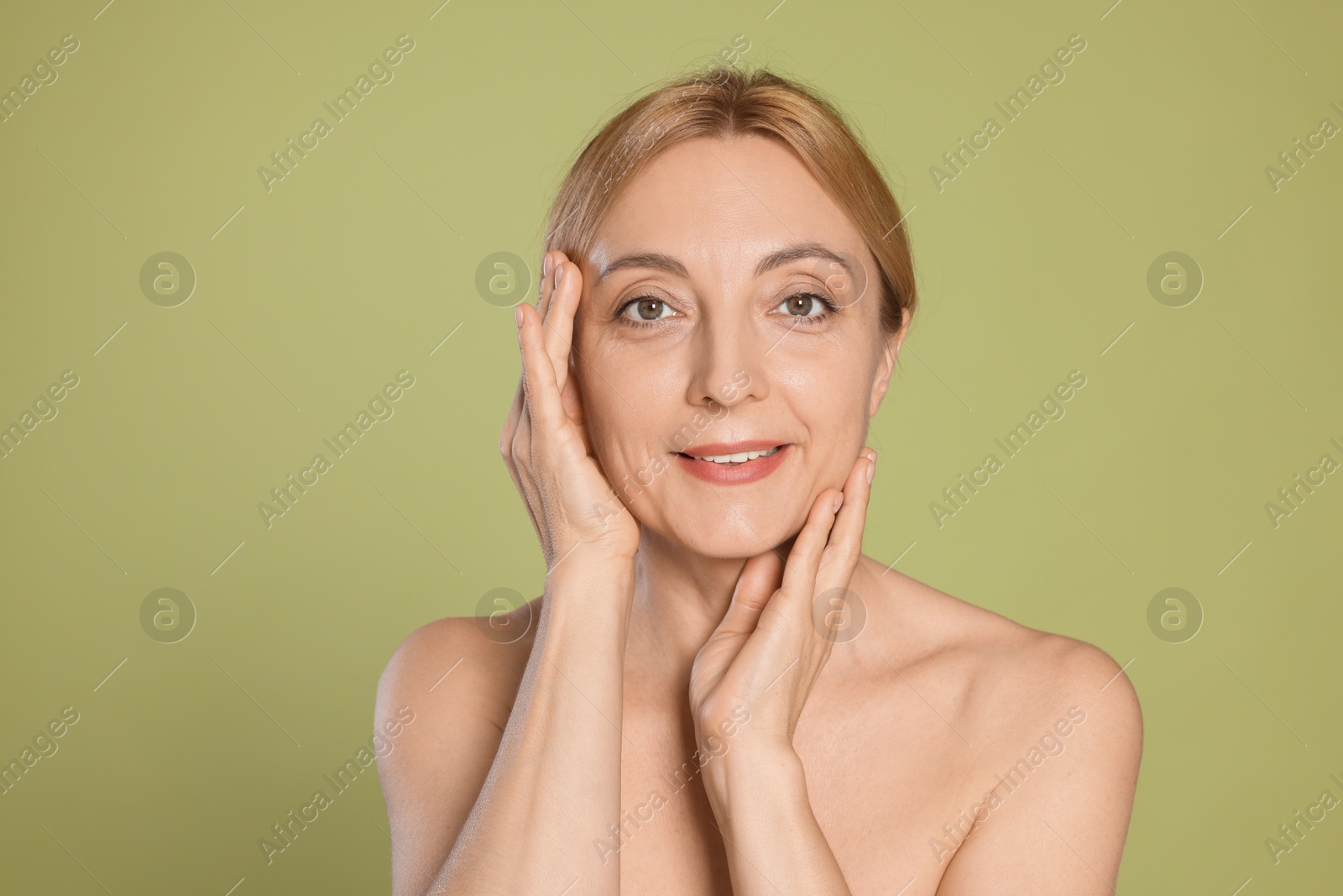 Photo of Portrait of smiling woman with healthy skin on green background