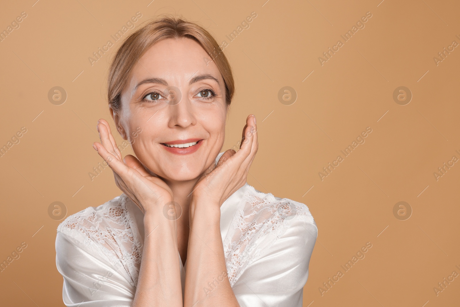 Photo of Portrait of smiling woman with healthy skin on beige background. Space for text