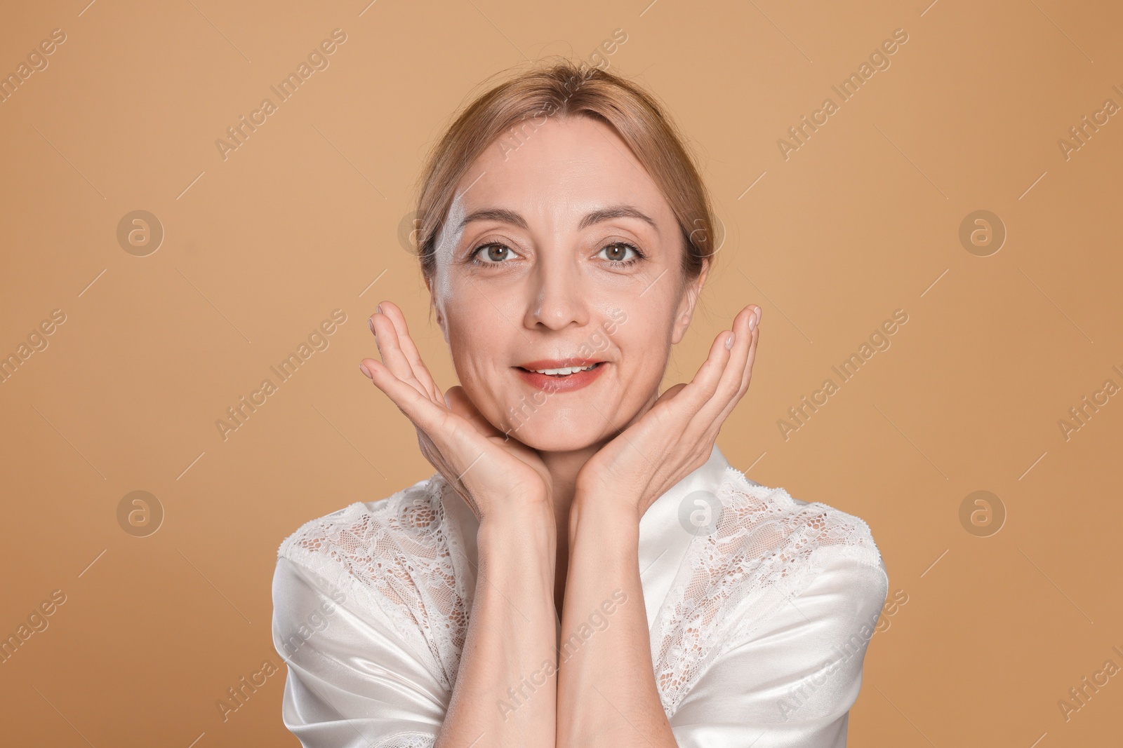 Photo of Portrait of smiling woman with healthy skin on beige background