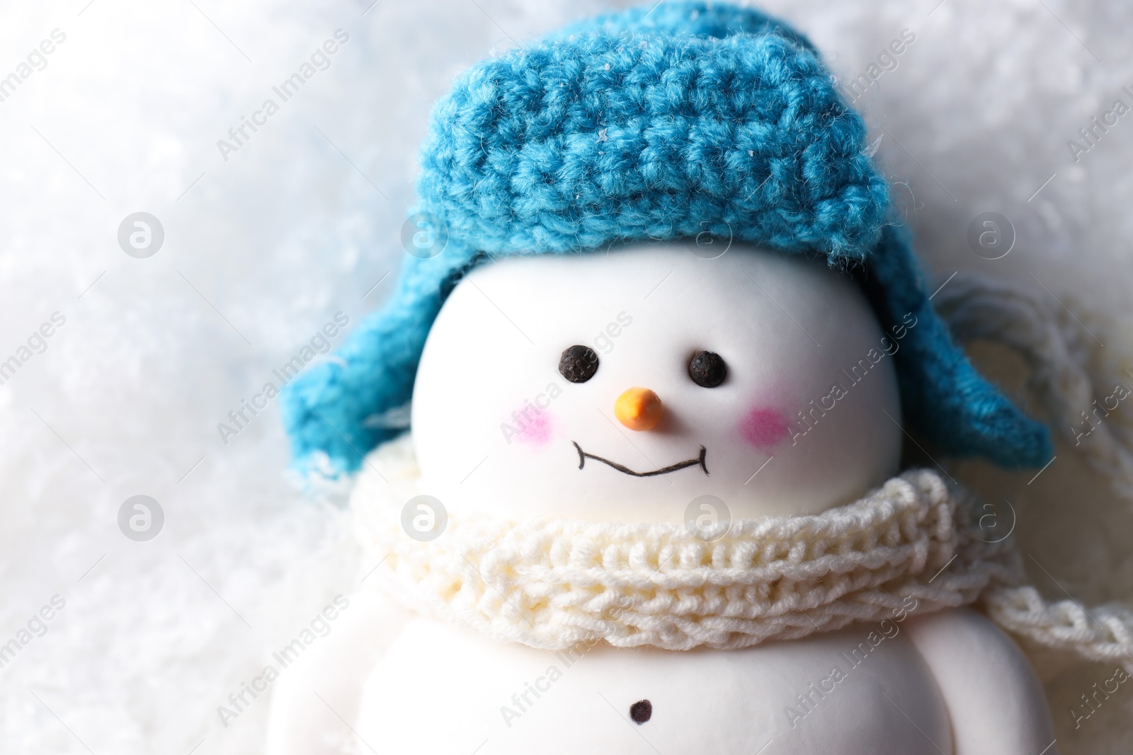 Photo of Cute decorative snowman on artificial snow, top view