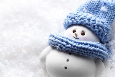 Photo of Cute decorative snowman on artificial snow, closeup. Space for text