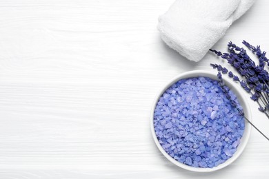 Photo of Spa composition with sea salt, towel and lavender flowers on white wooden table, flat lay. Space for text