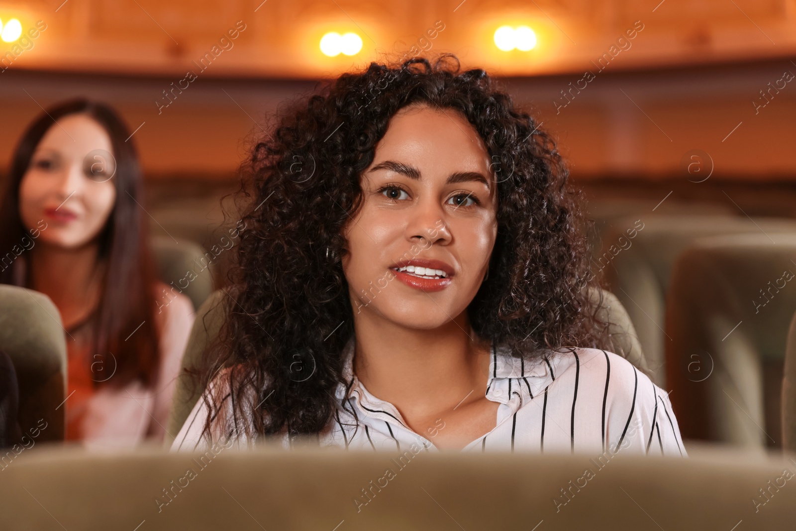 Photo of Two women watching theatrical performance in theatre