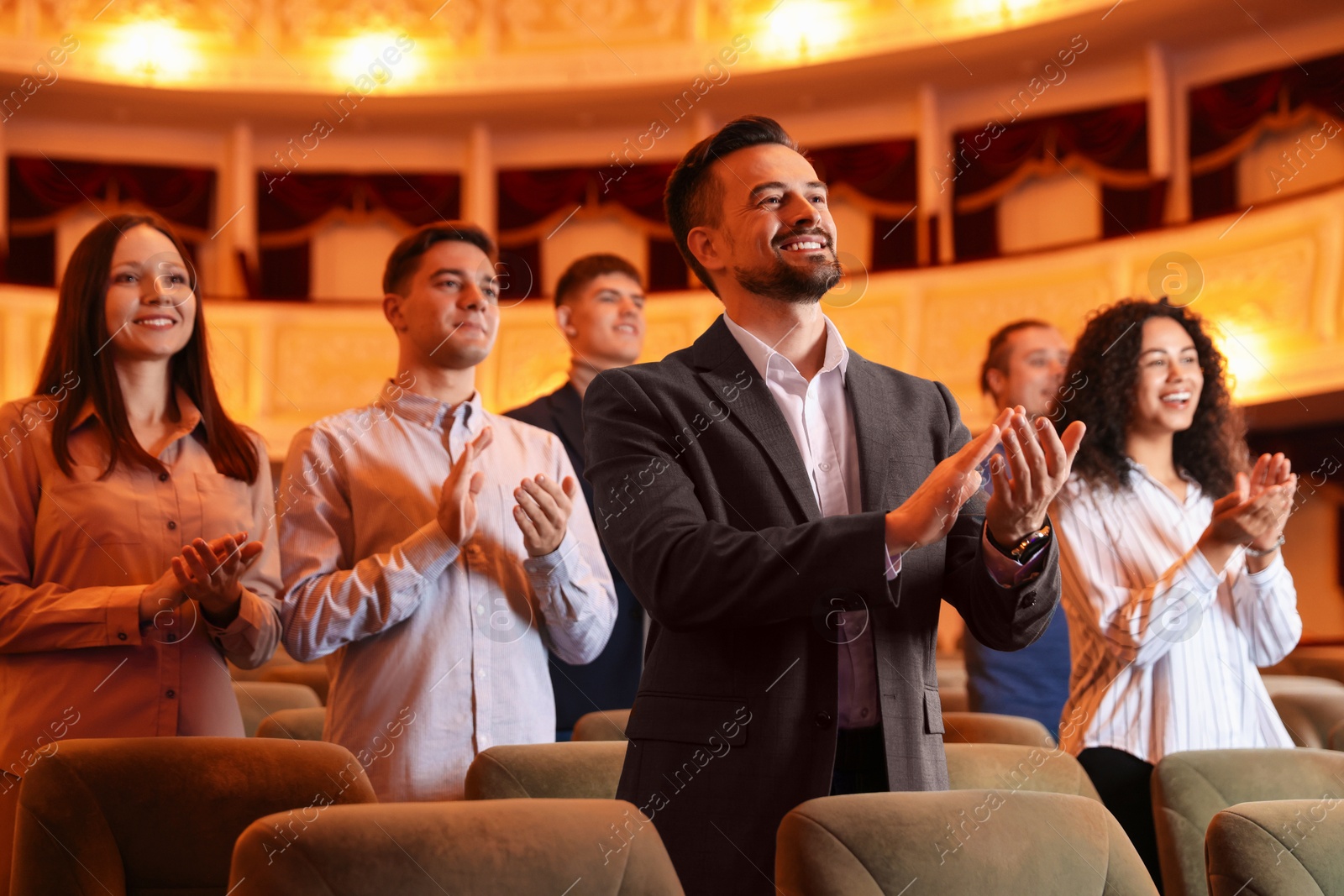 Photo of Group of exited people applauding in theatre