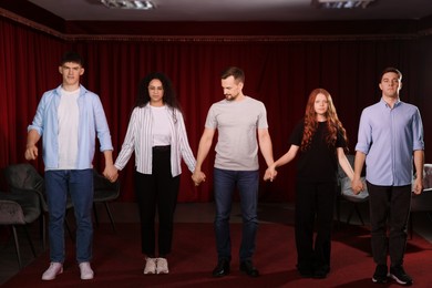 Photo of Professional actors bowing on stage in theatre