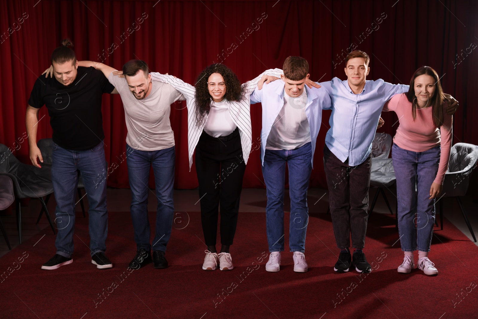 Photo of Professional actors bowing on stage in theatre