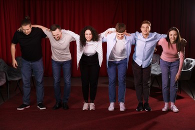 Photo of Professional actors bowing on stage in theatre