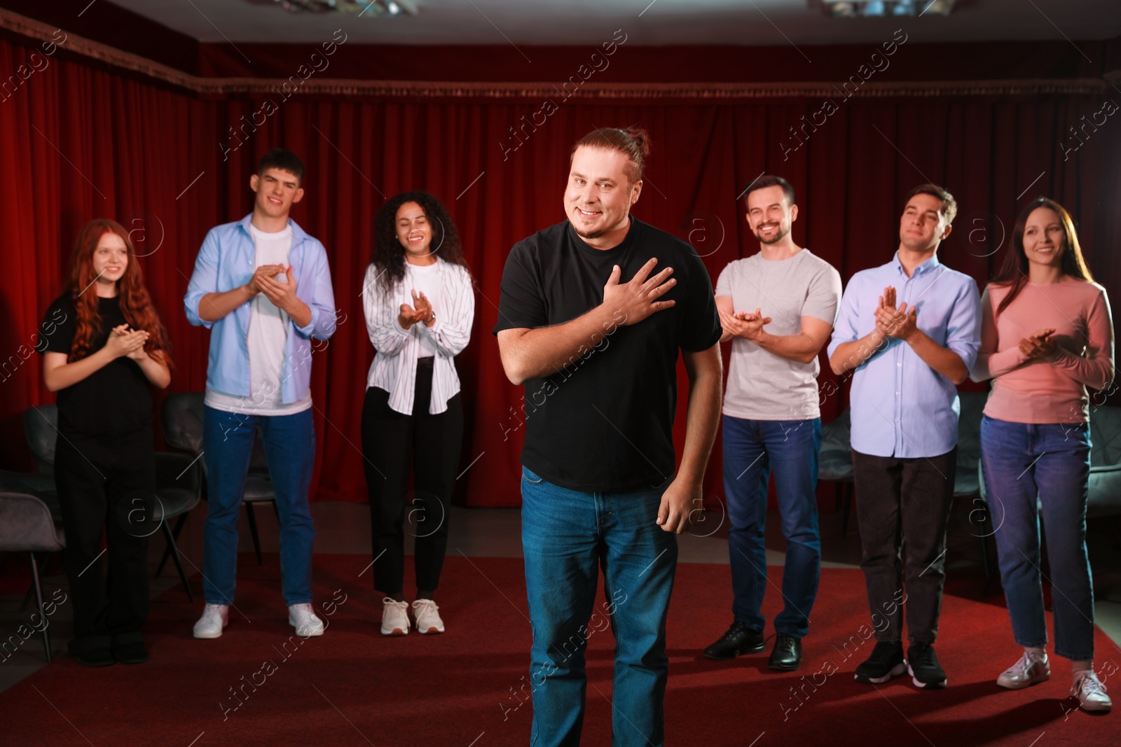 Photo of Professional actors bowing on stage in theatre