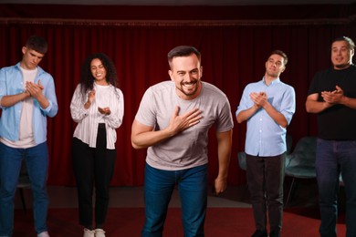 Professional actors bowing on stage in theatre