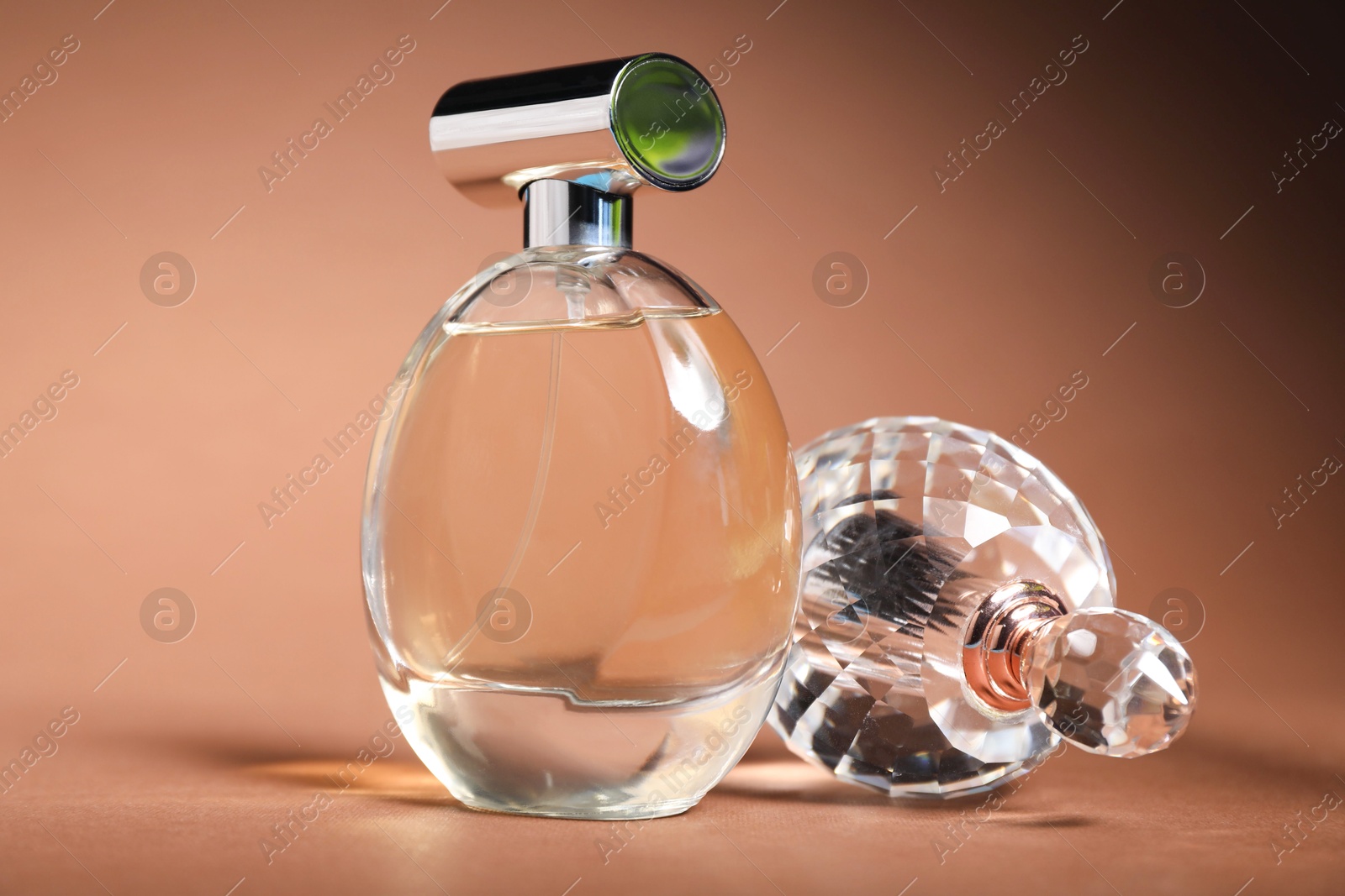 Photo of Bottles of fragrant perfume on brown background, closeup