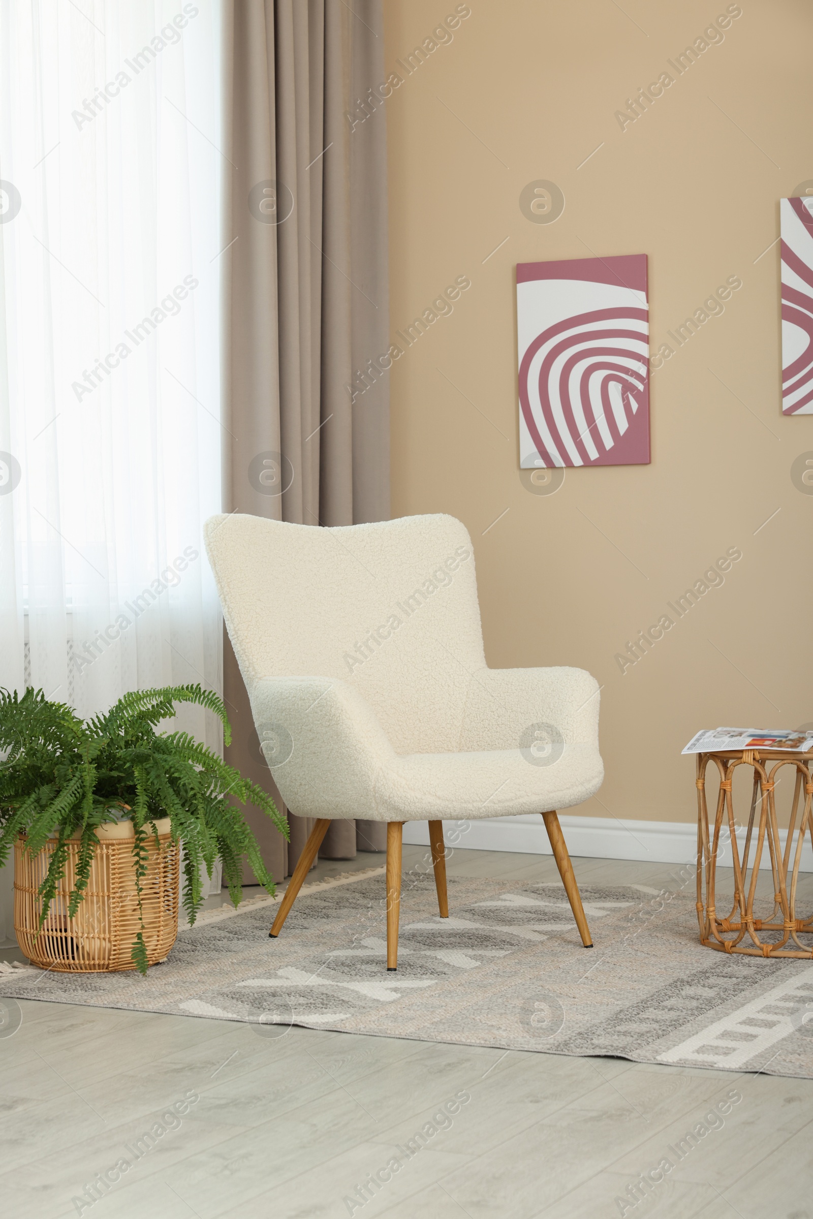 Photo of Soft armchair near beige wall at home