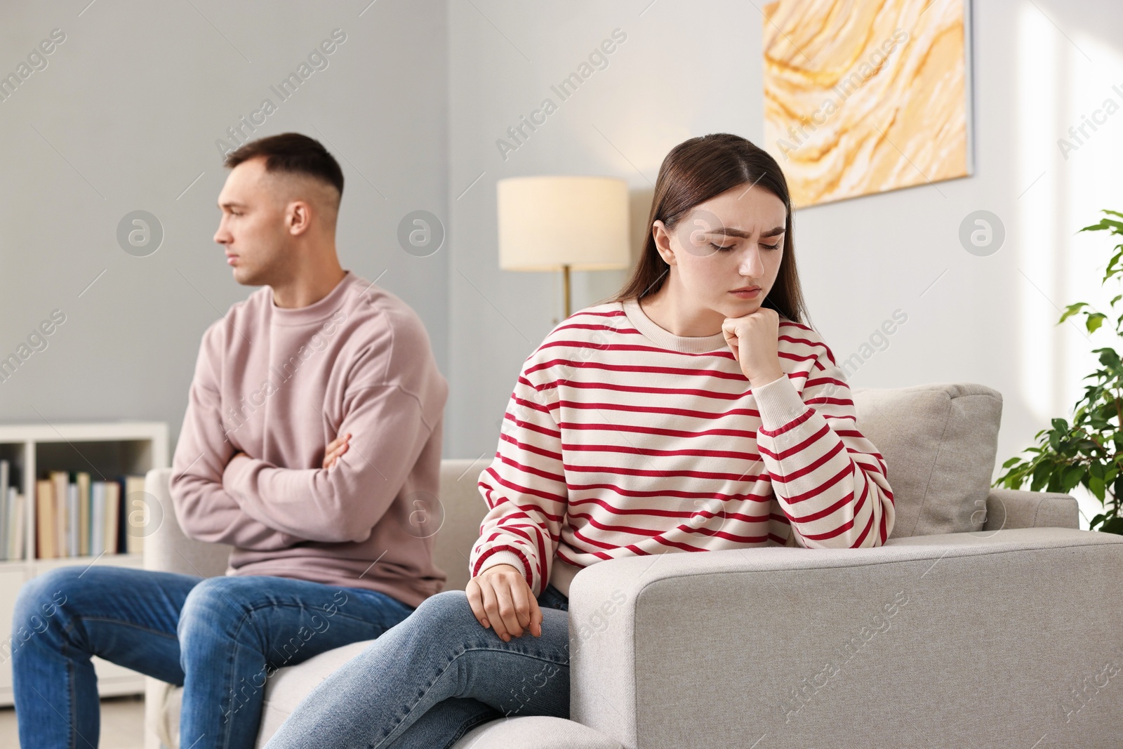 Photo of Offended couple ignoring each other at home